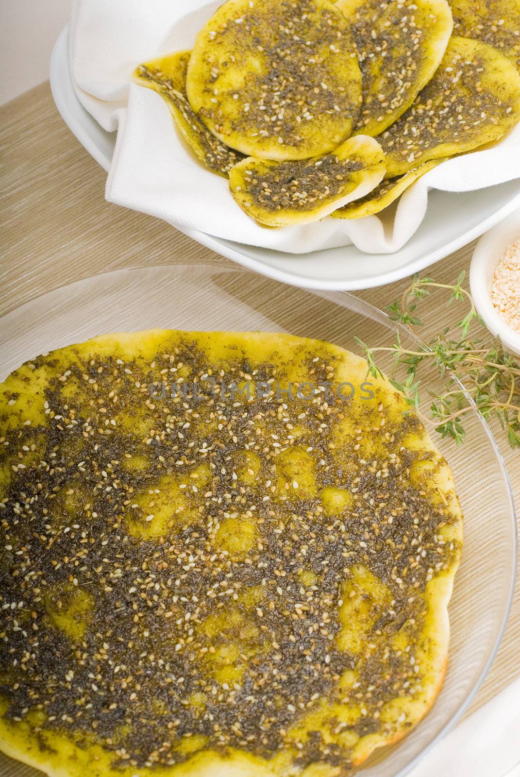 lebanese manouche or manoushe ,lebanese pizza with thyme and sesame seeds,zaatar, and extra virgin olive oil on top