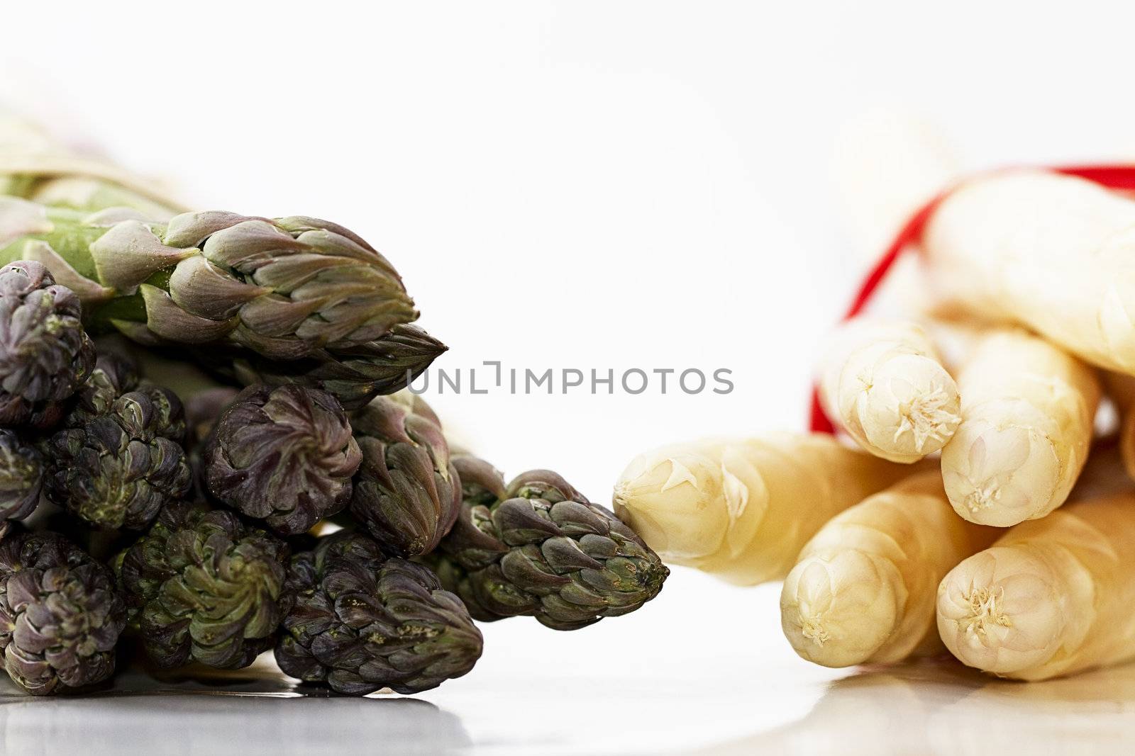 tips of green and white asparagus on white background