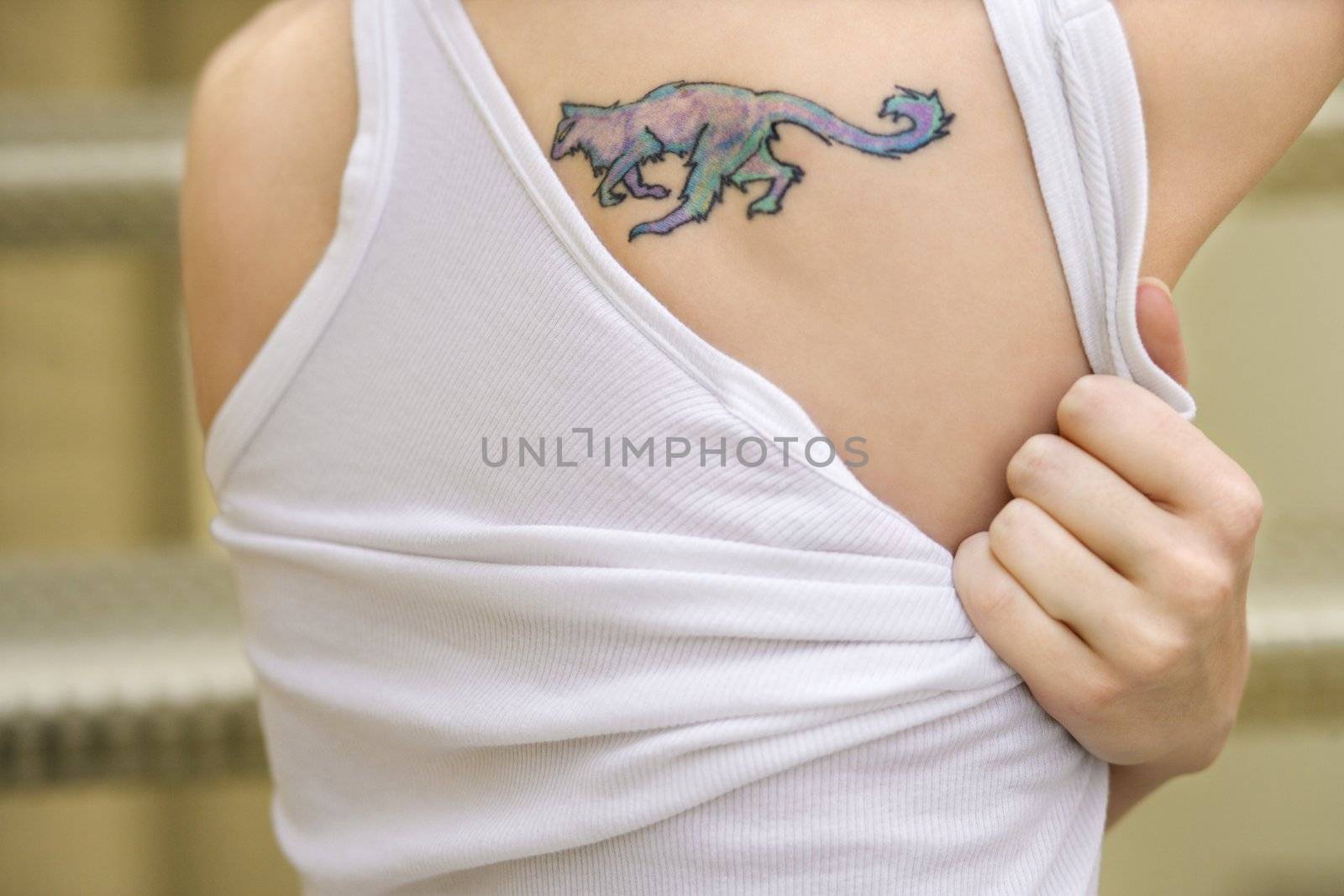 Portrait of young Caucasian woman with tattoo on shoulder.