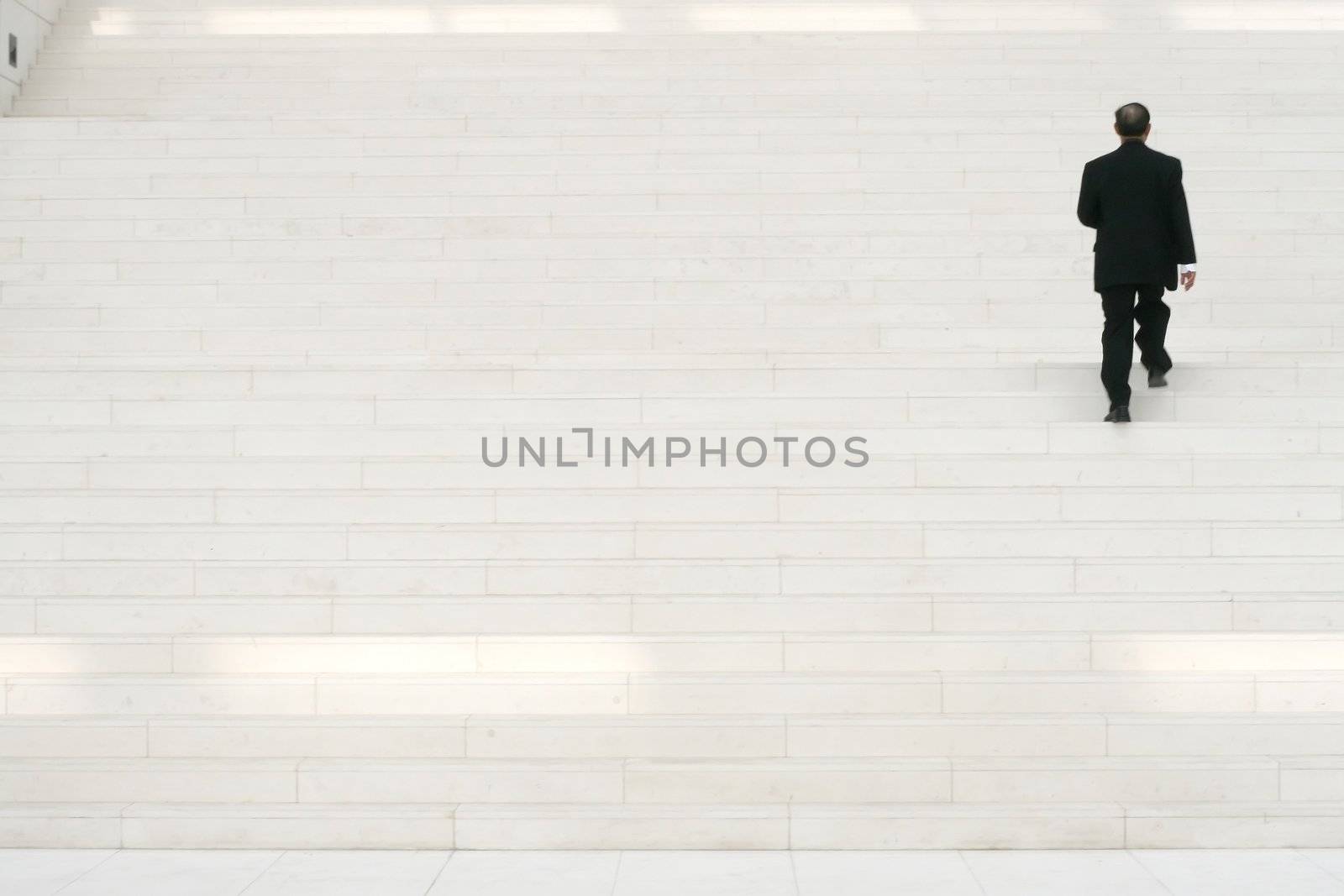 businessman in black suit going on stairs