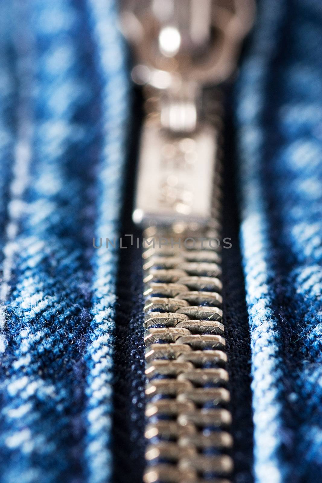 Macro shot of closed zipper on a blue jeans. Shallow depth of field