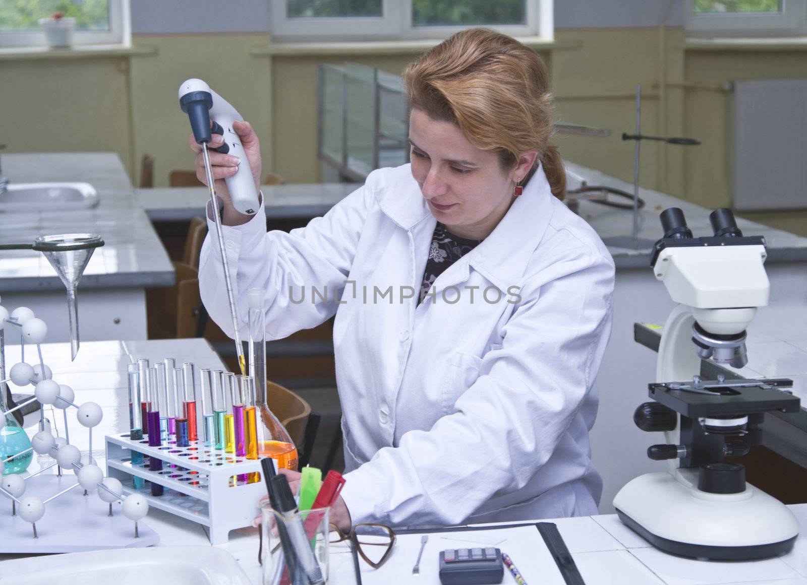 Image of a researcher pipetting solutions into the tubes in a laboratory.