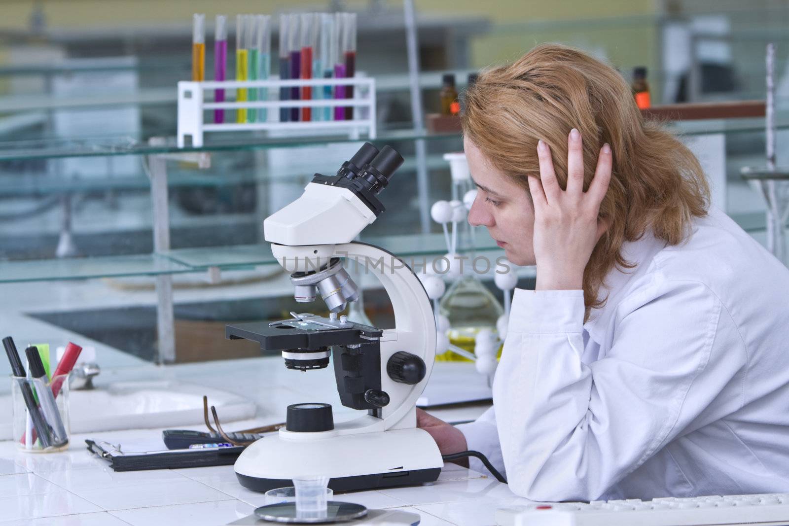 Female reasearcher thinking at his workplace in a laboratory.