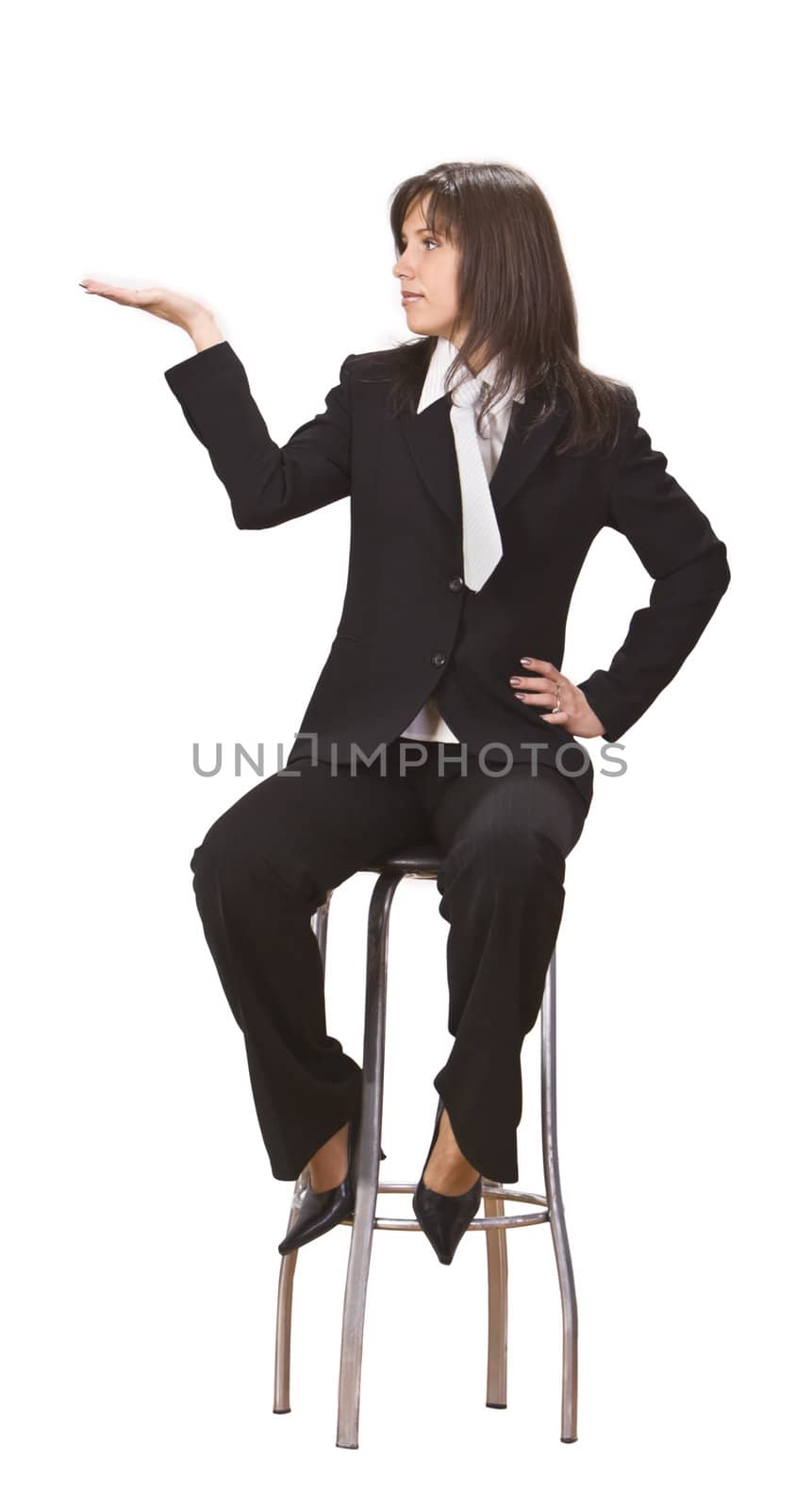 Young businesswoman sitting on a high chair and holding out her hand as if she were displaying something.You can add any text or object on the palm of her hand.