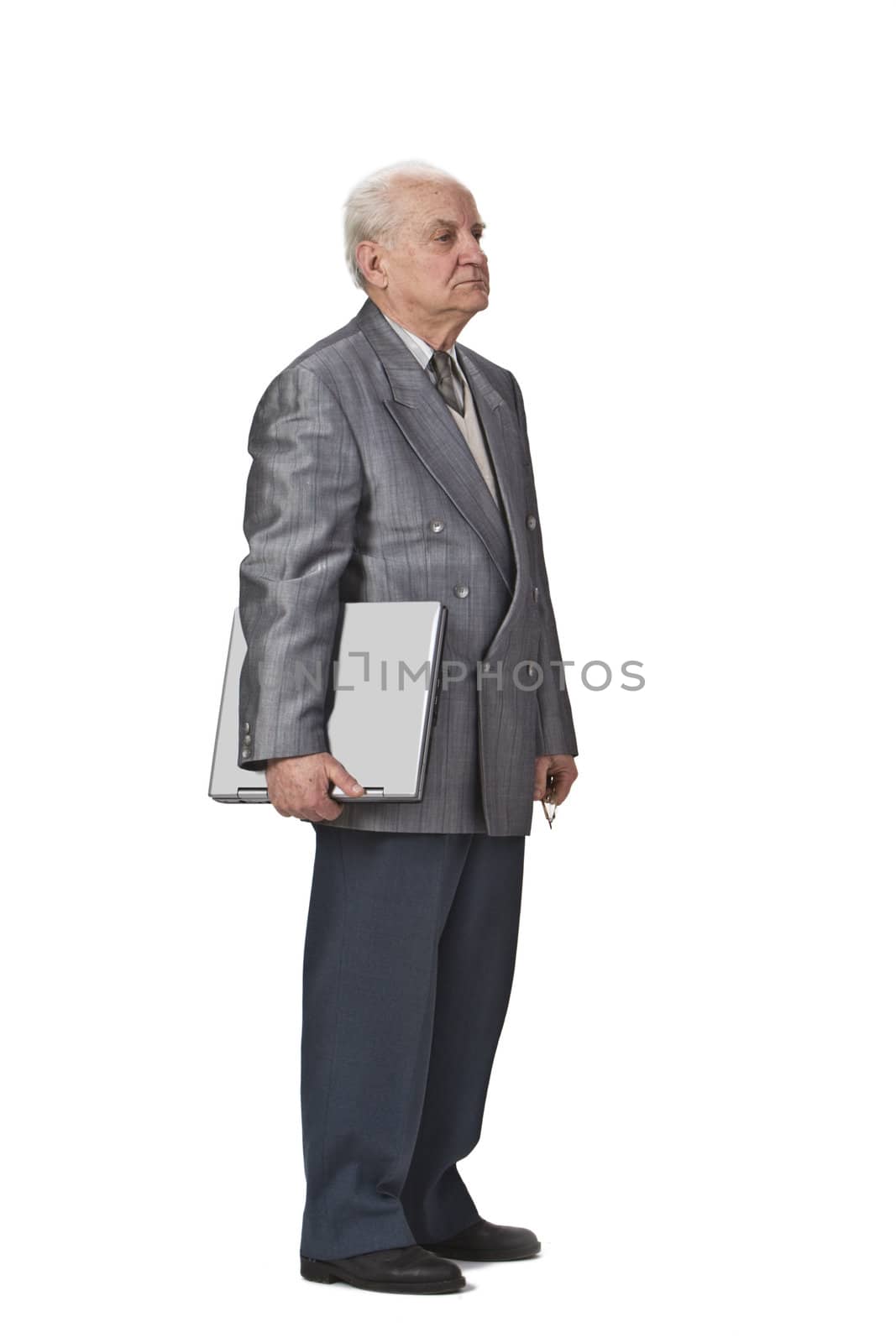 Image of a sehior man holding a laptop and standing-up against a white background,side view.