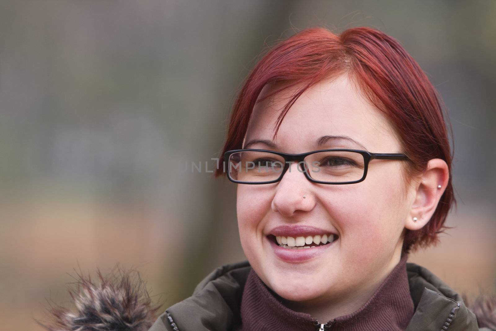 Autumn portrait of a redheaded girl with glasses.