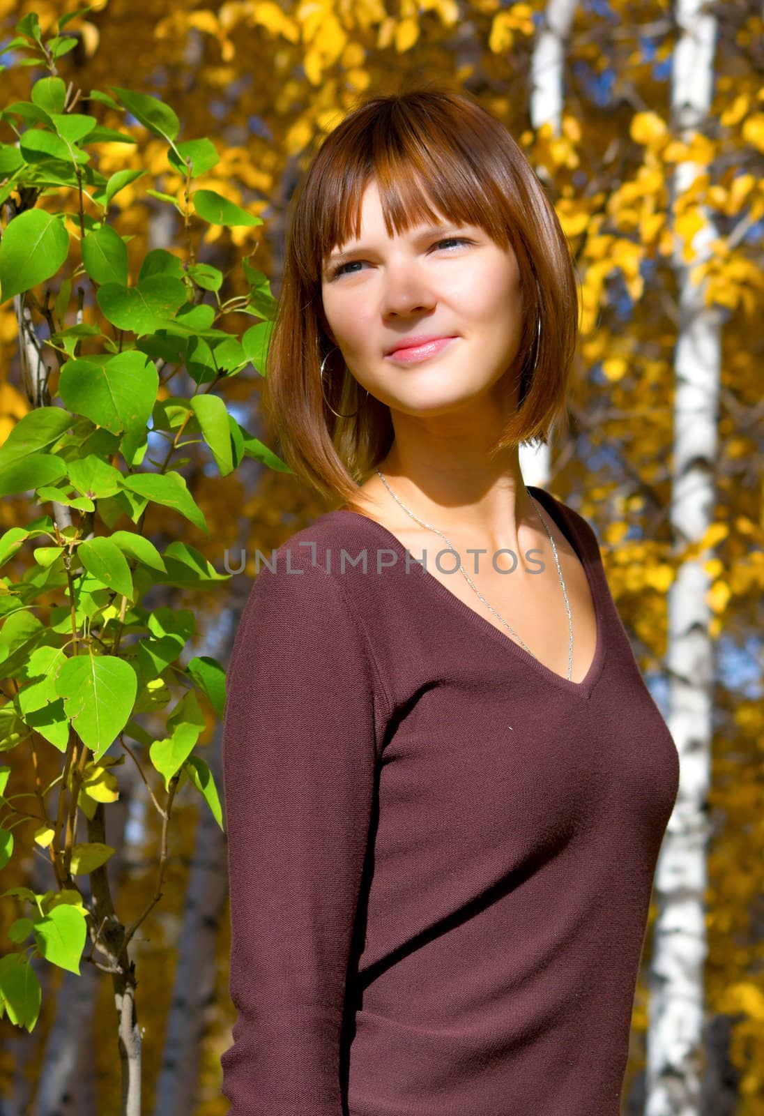 Portrait of the beautiful young girl against green foliage