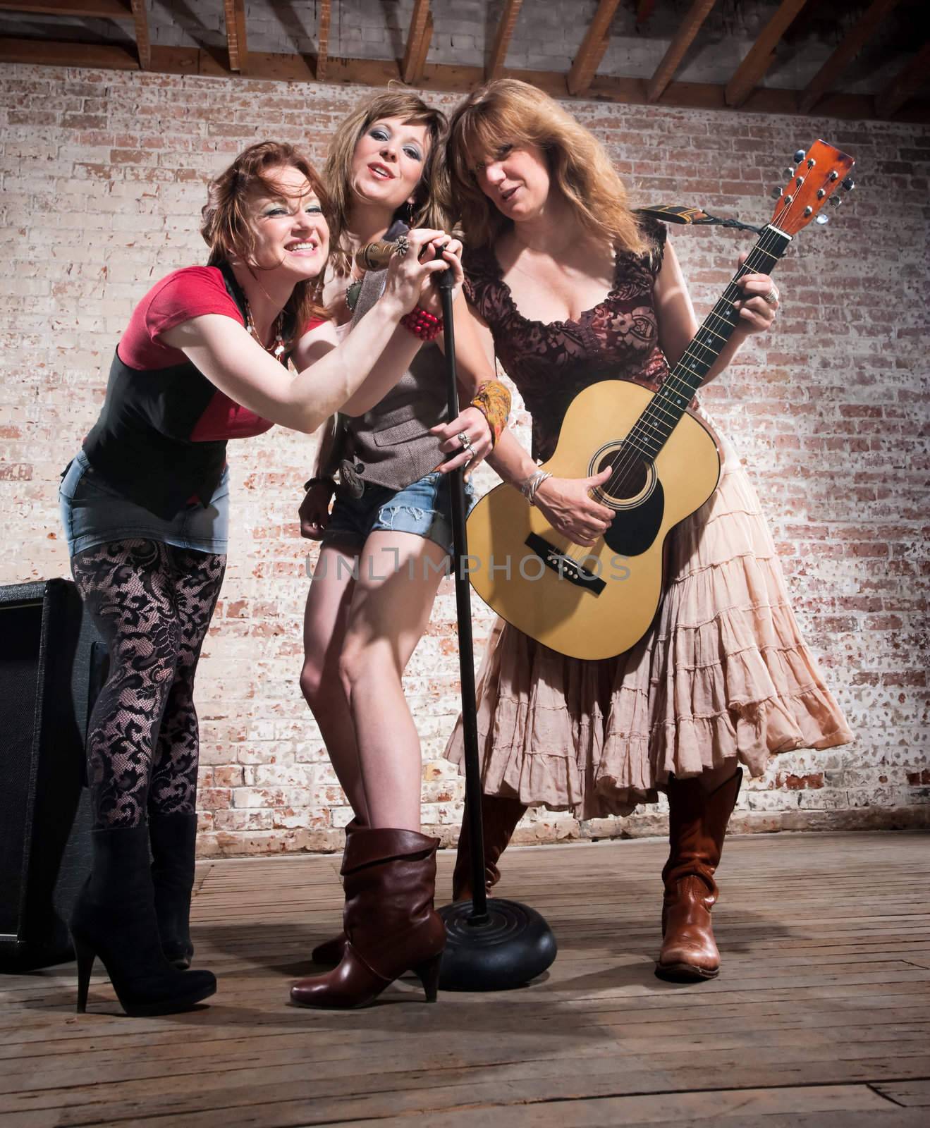 All-girl trio performing in stylish clothing at a warehouse