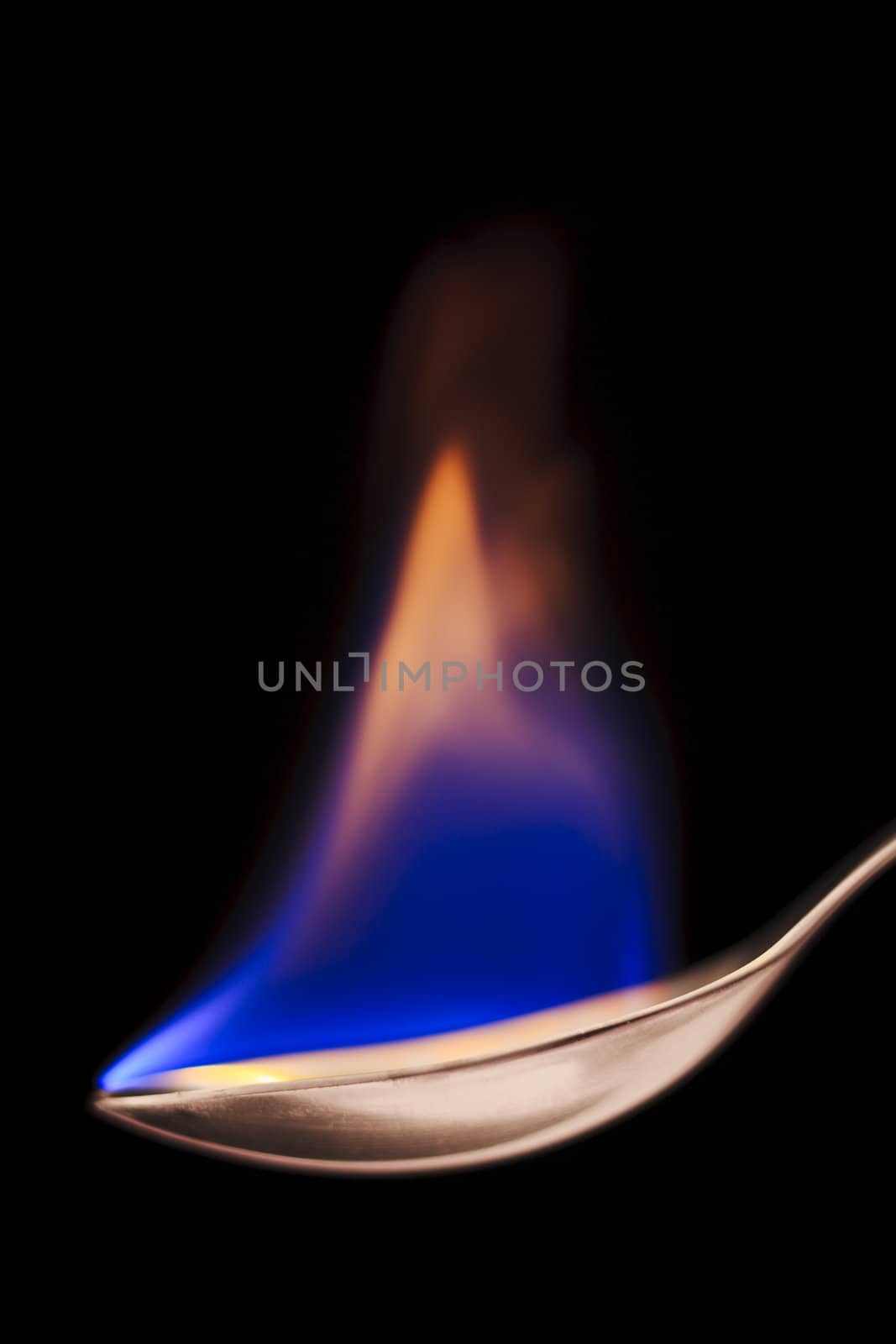 Close up of flaming spoon over black background