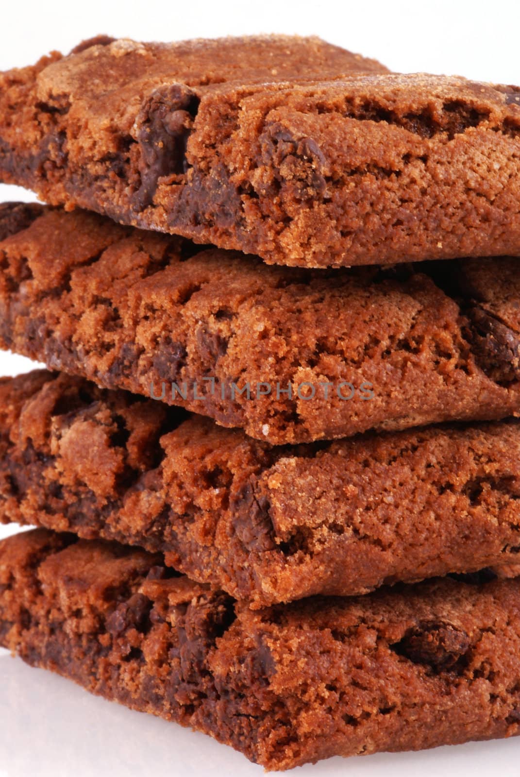 Close up of a pile of chocolate cookies on white.