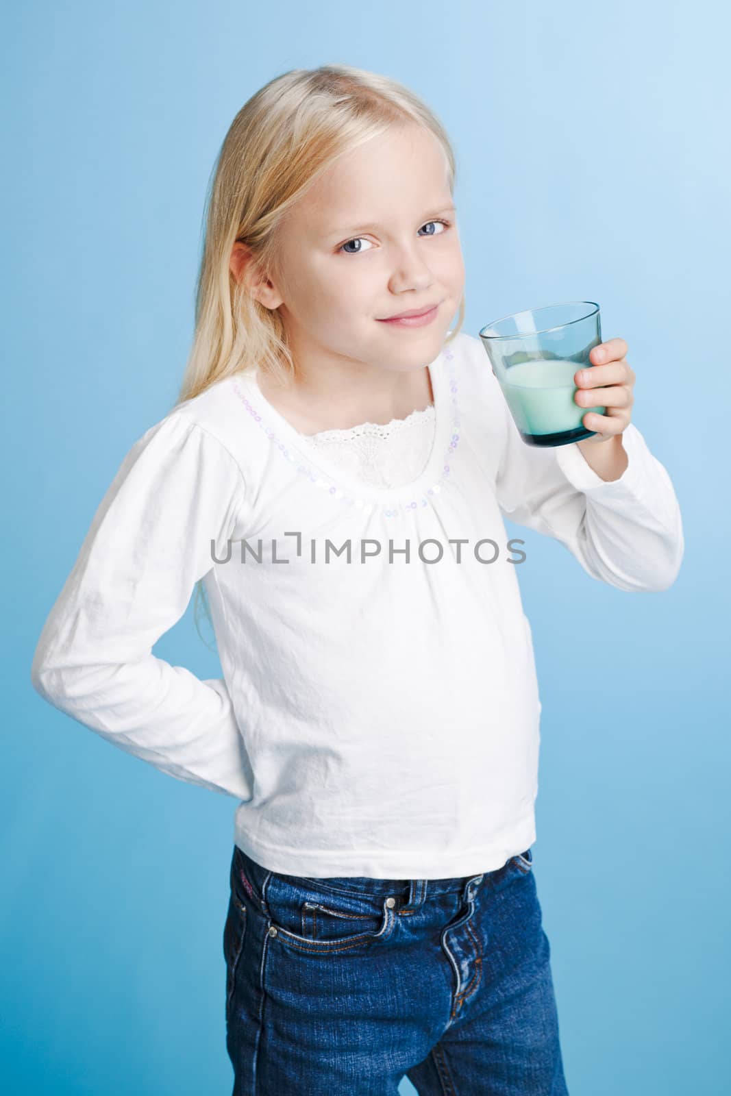 Young girl holding milk glass over a blue background