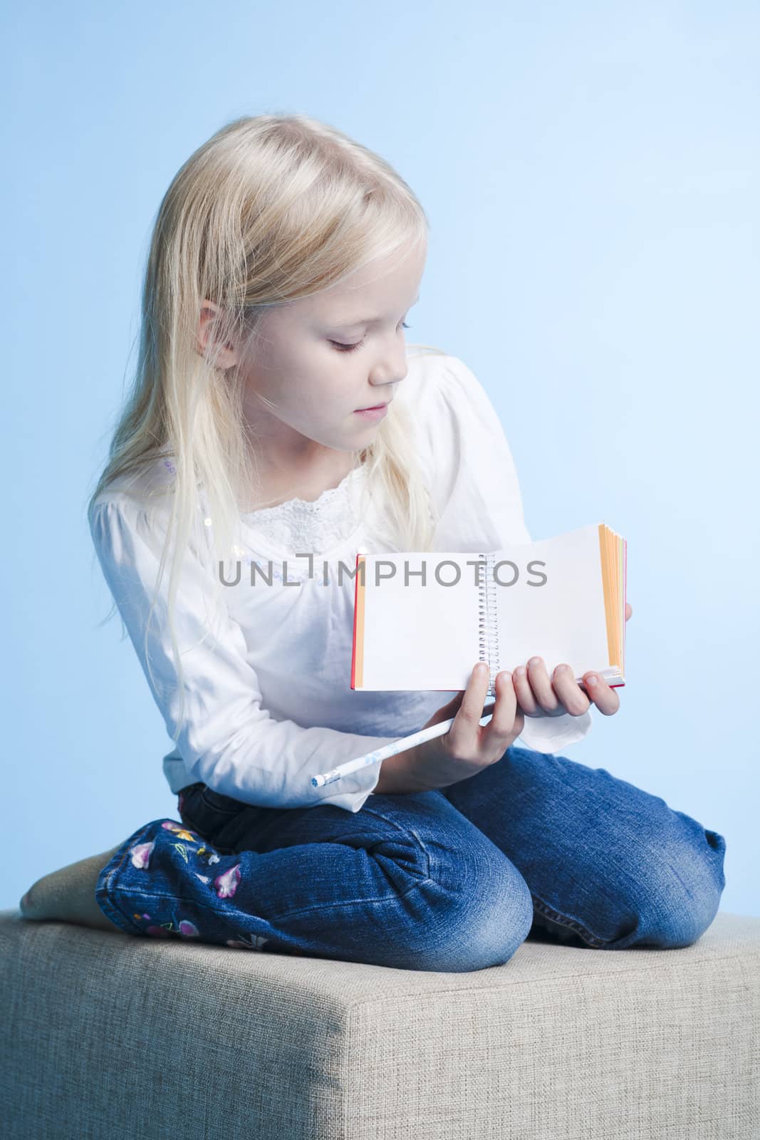 Young girl showing a book page over blue background