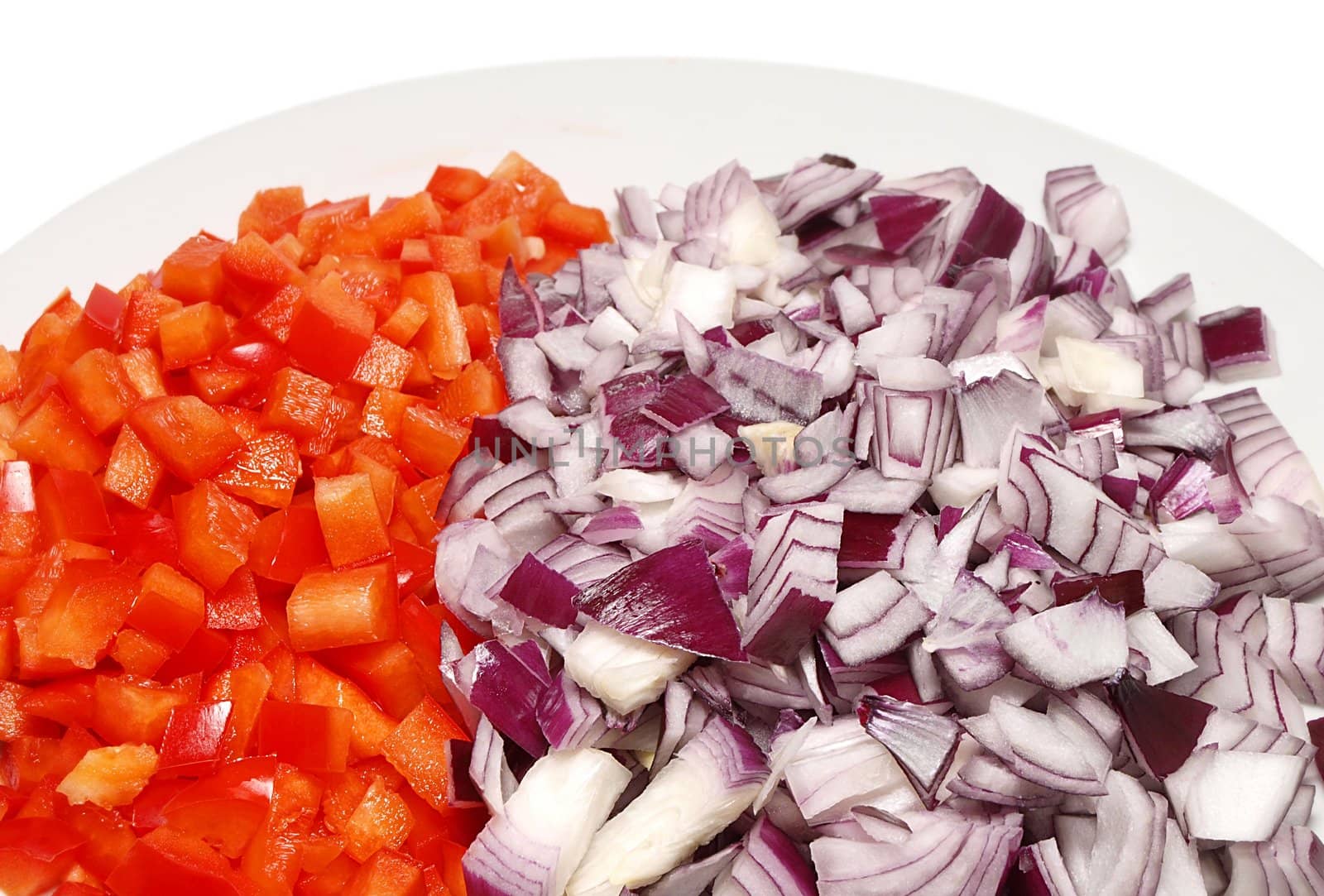 Red pepper and red onion sliced into dices on a white plate