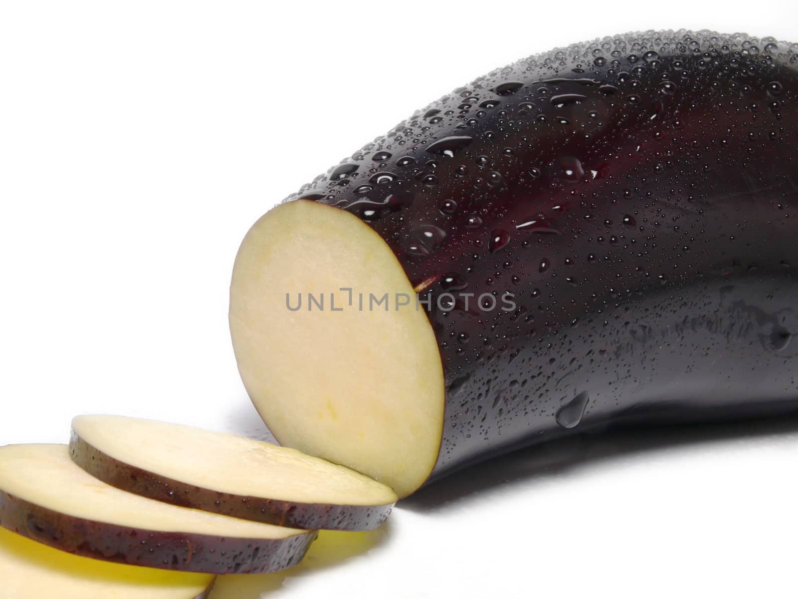 Fresh purple eggplant vegetable with droplets, sliced, towards white background