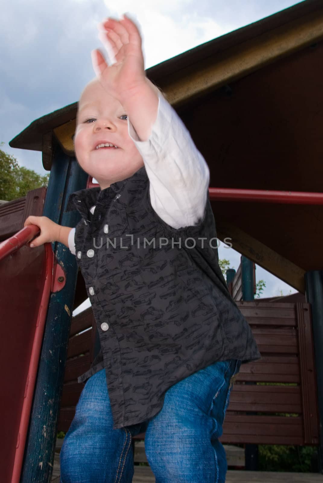 a little boy standing on a shute becking 