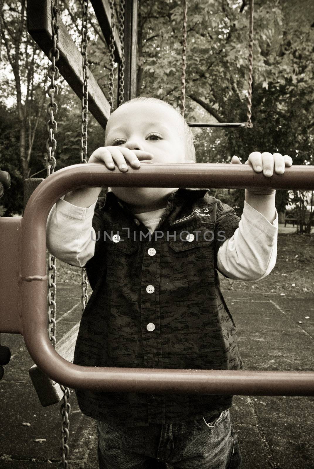 a little boy looking over a barrier at the playground