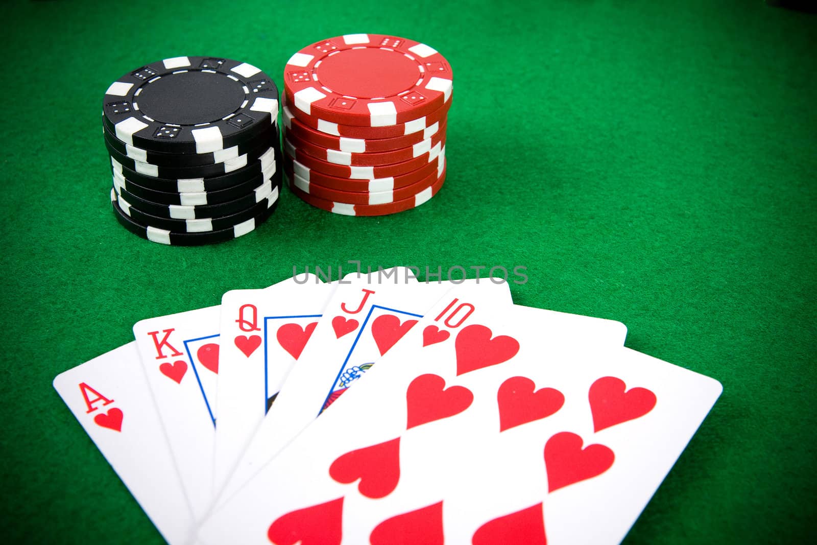Poker arrangement with poker chips on green poker table.