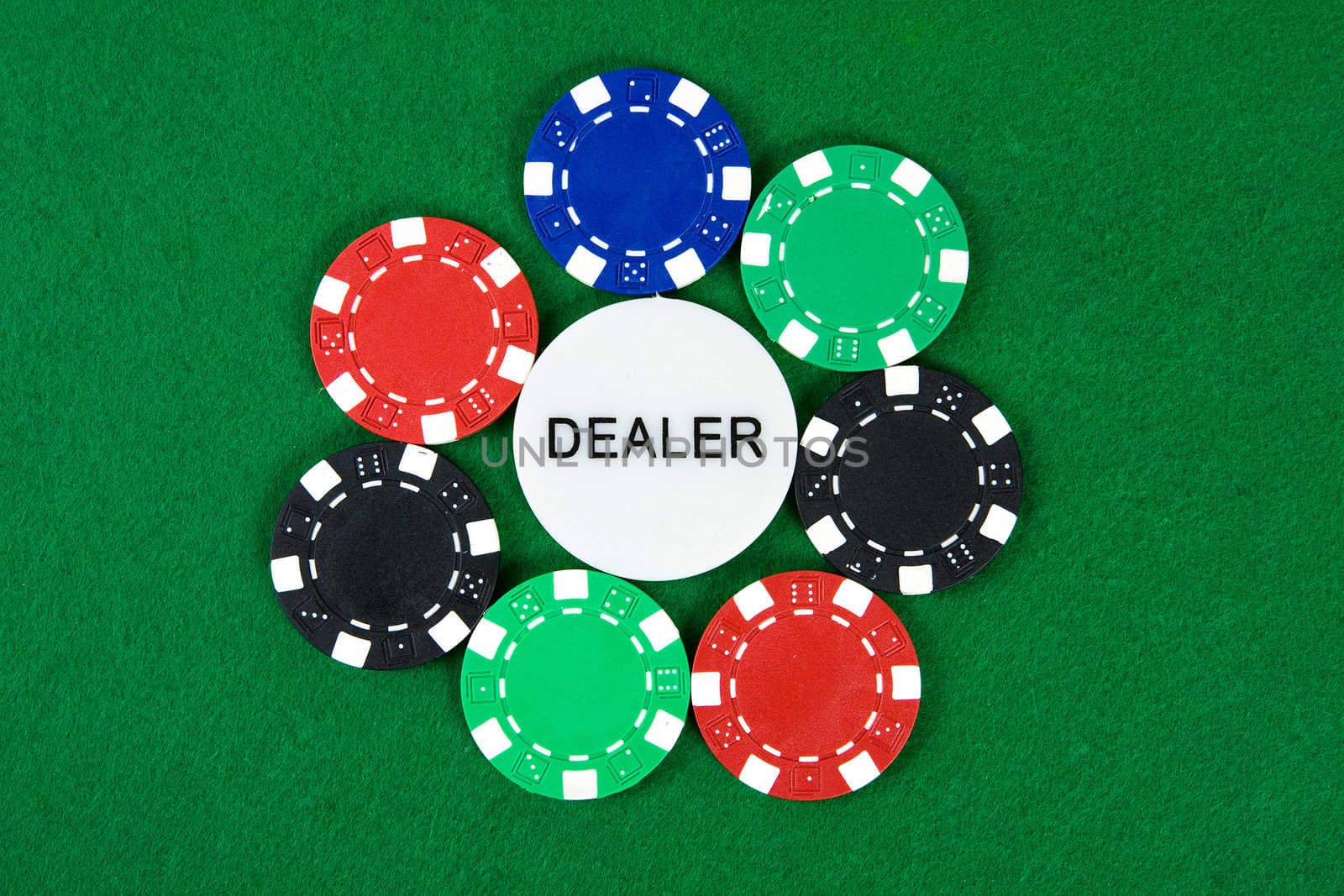 Poker chips arranged in a circle with dealer chip in the middle