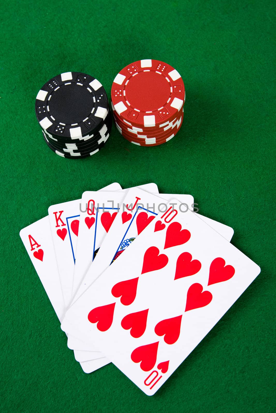 Poker arrangement with poker chips on green poker table.