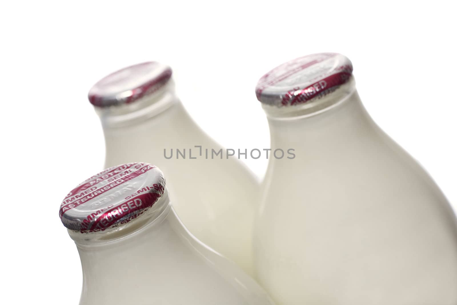 Three bottles of semi-skimmed milk on a white background