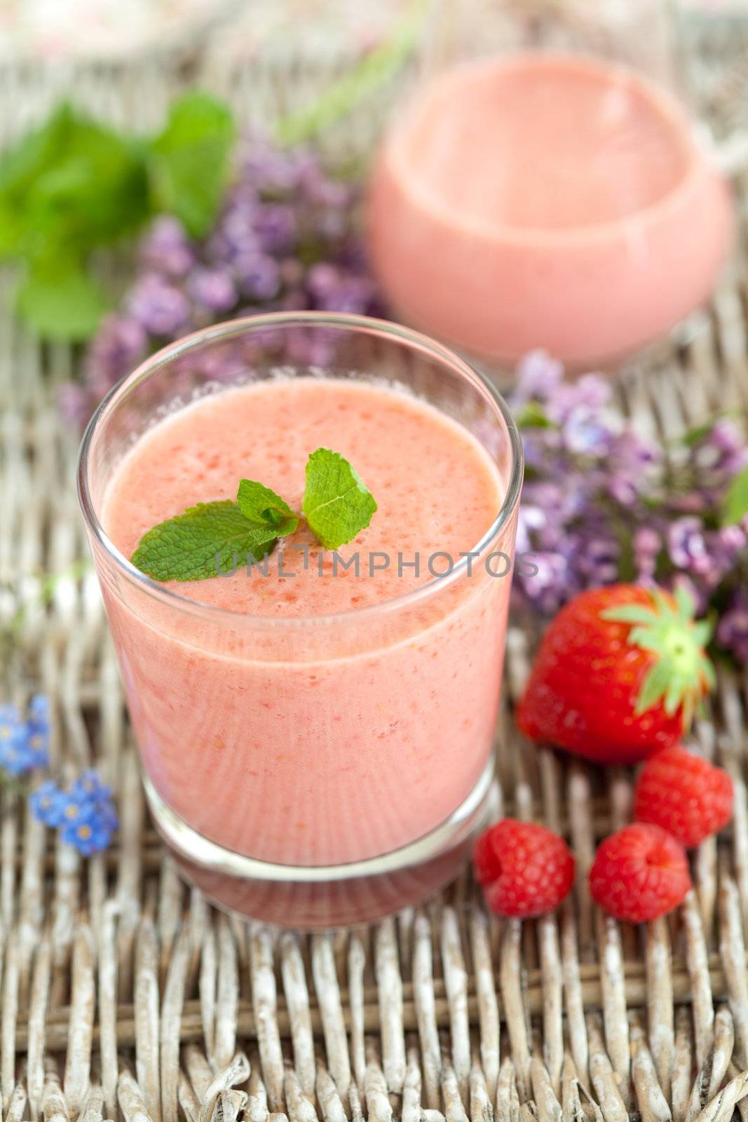 Delicious drink with strawberries and raspberries topped with mint