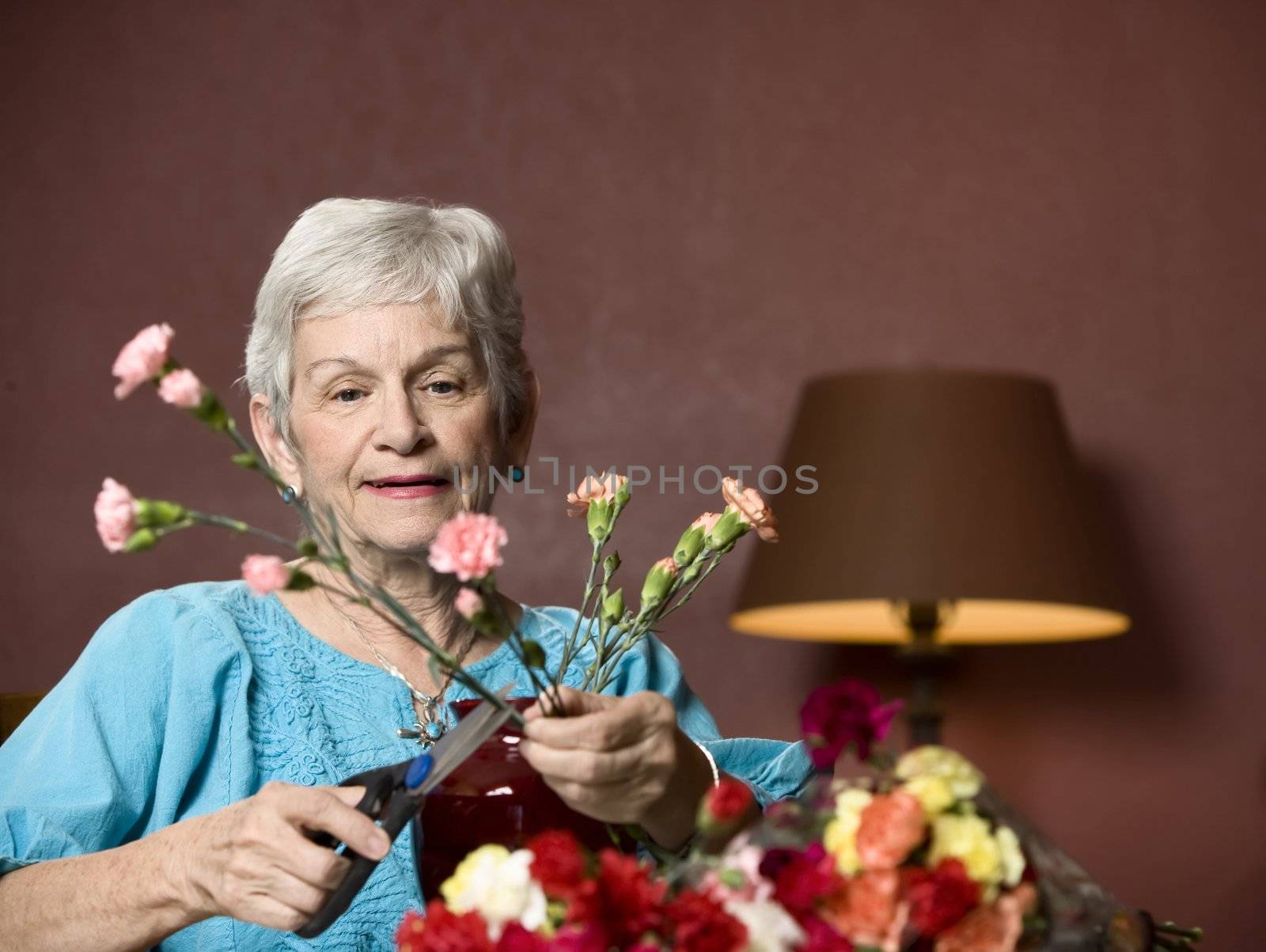Senior woman at home with colorful flowers