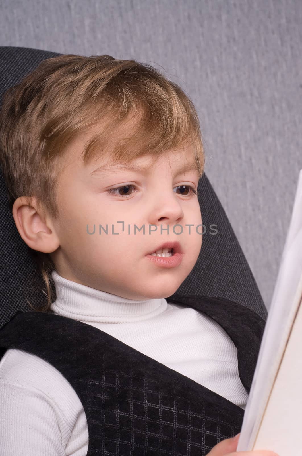 Six years boy reading a book at home