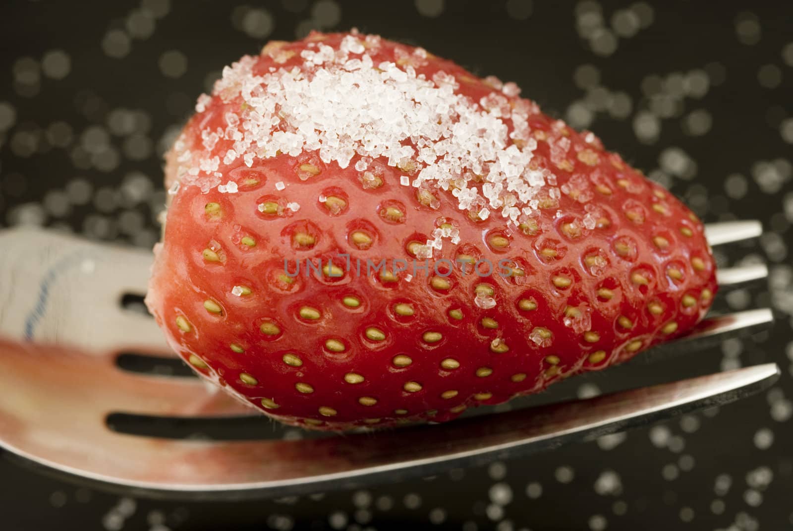 a ripe red strawberry, sprinkled with sugar, ready to eat