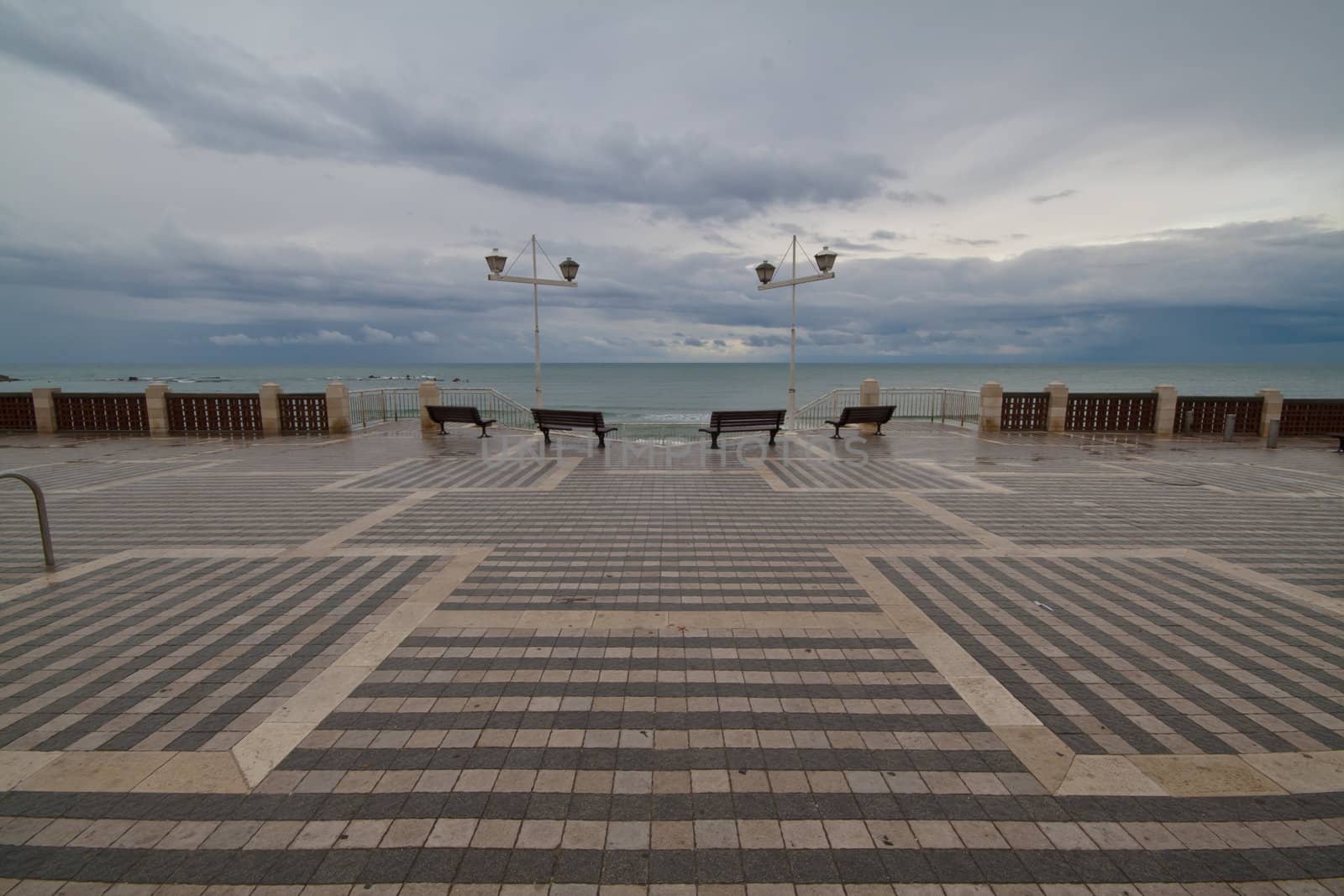 Four benches on the waterfront in rainy weather