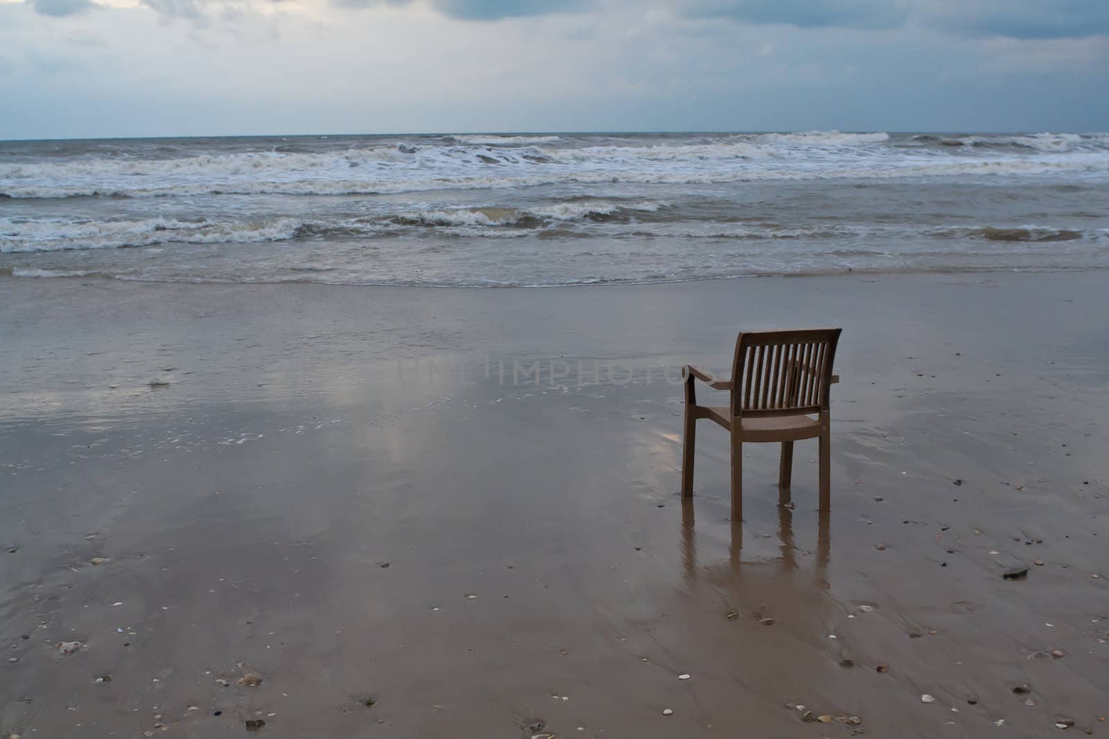 A lonely plastic chair on the beach