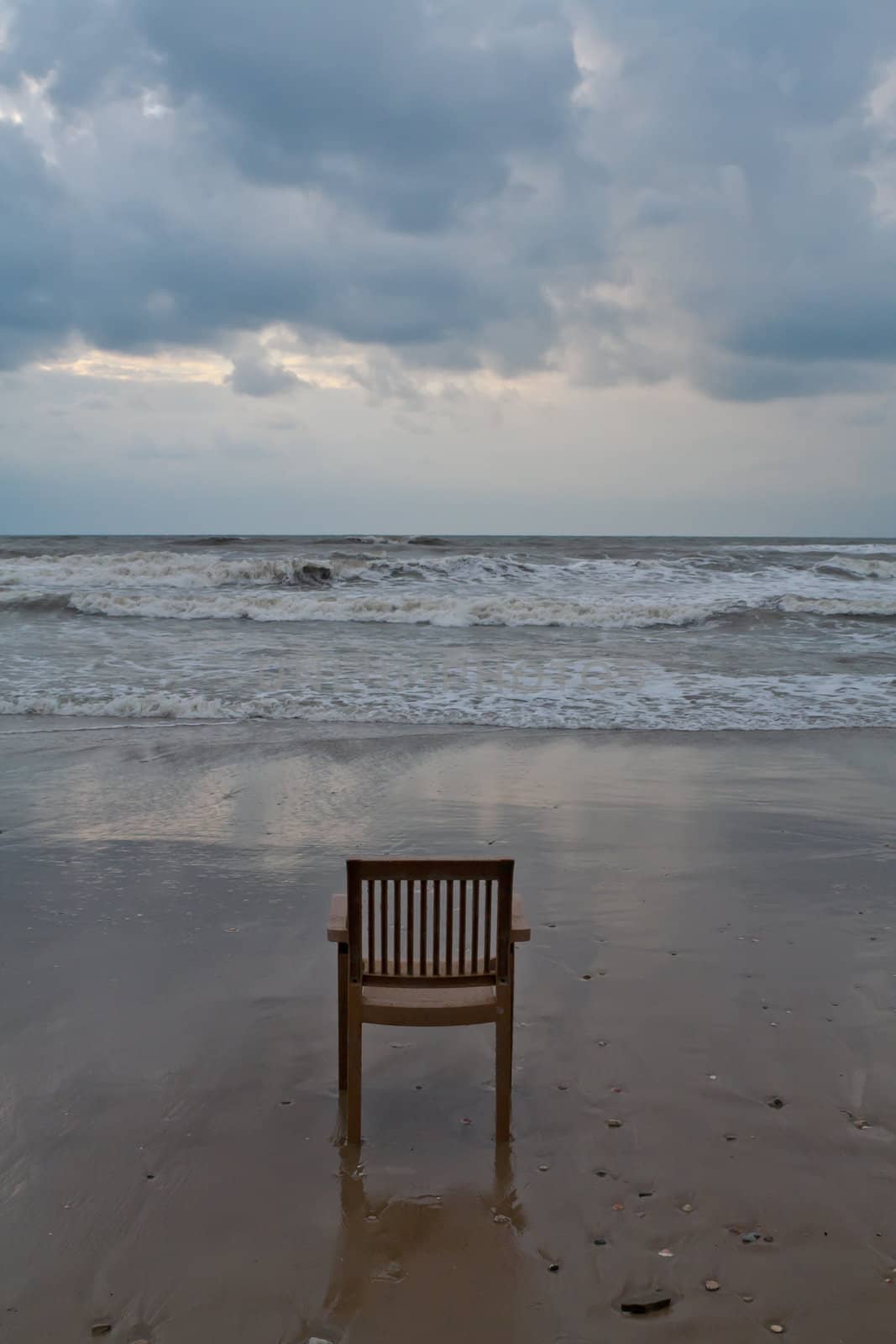 A lonely plastic chair on the beach