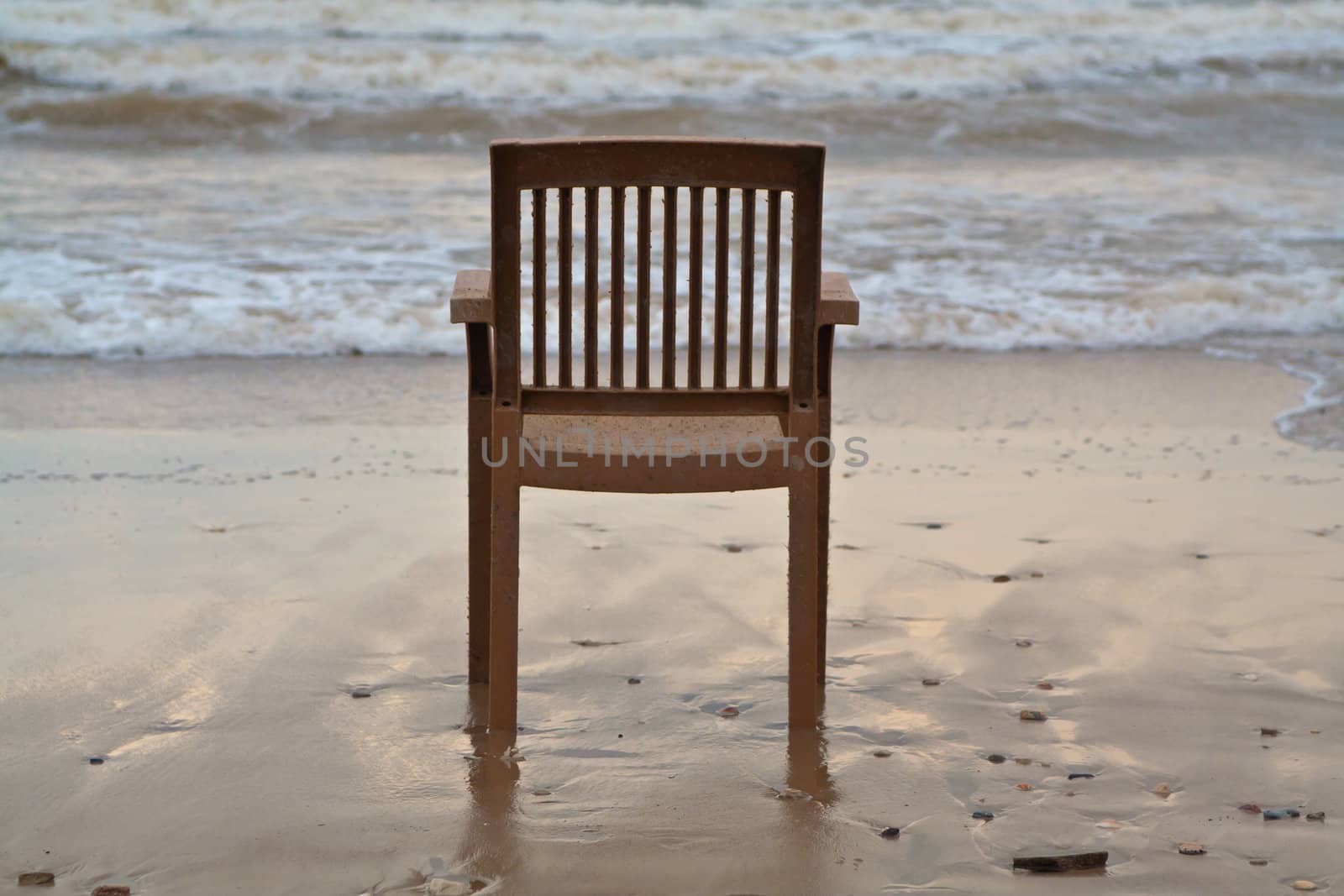 A lonely plastic chair on the beach