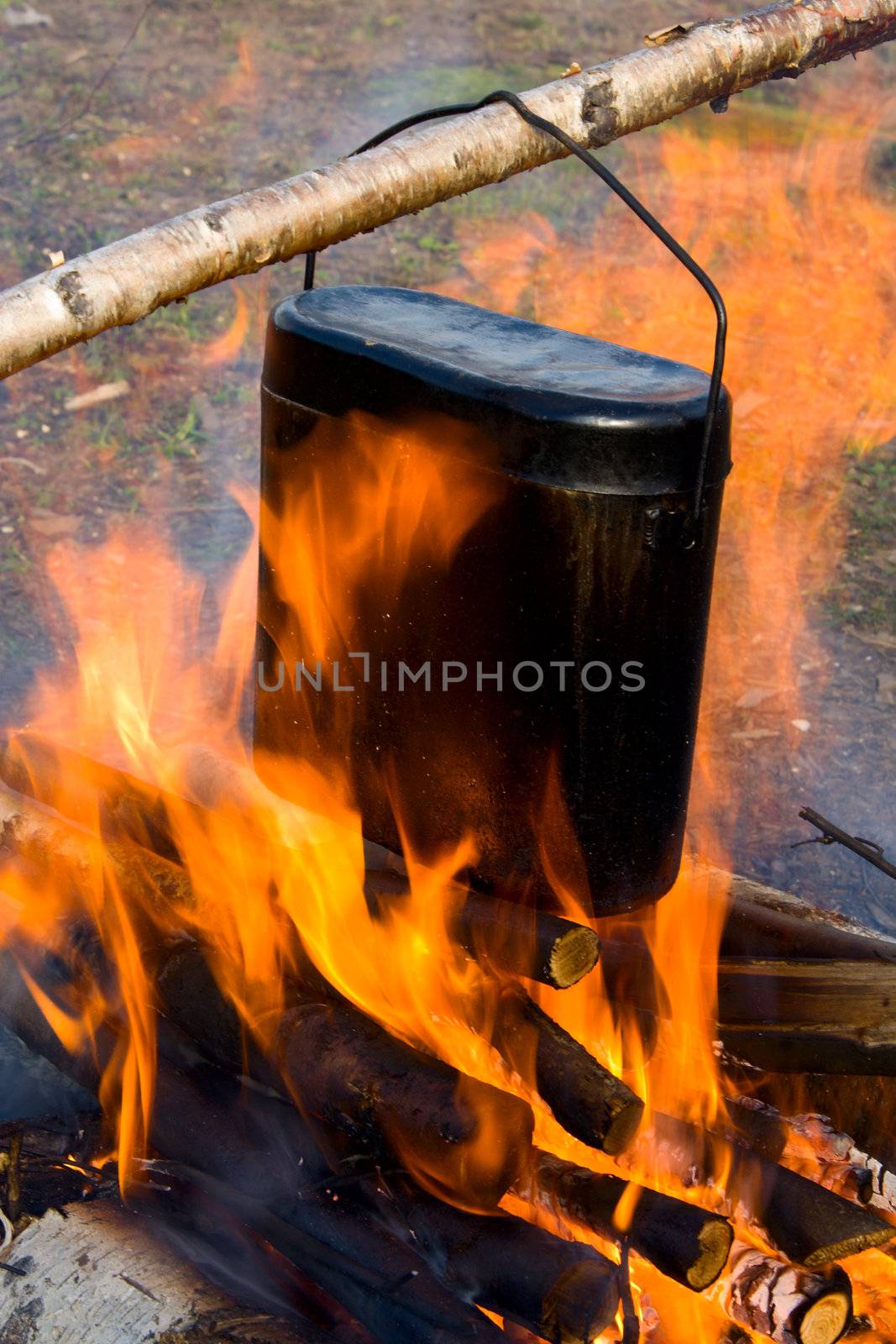 Cooking in a kettle on a fire.