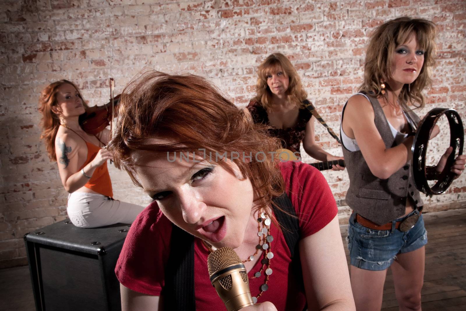 All-girl band performing in stylish clothing at a warehouse