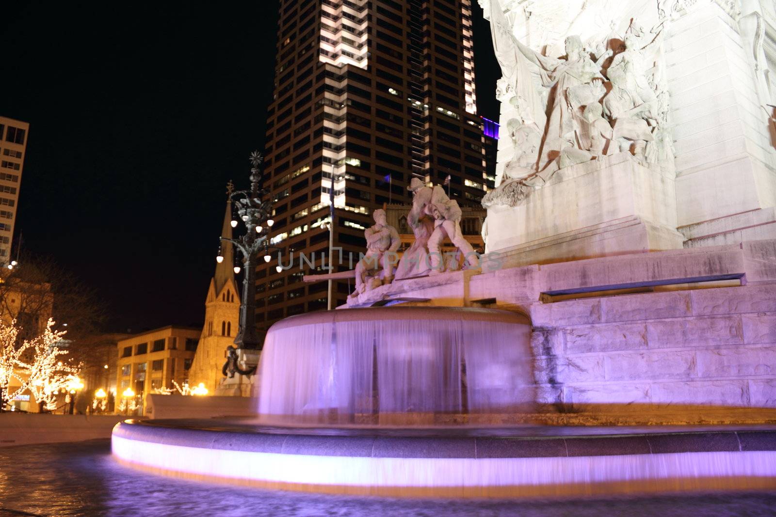 A city water fountain illuminated at night.