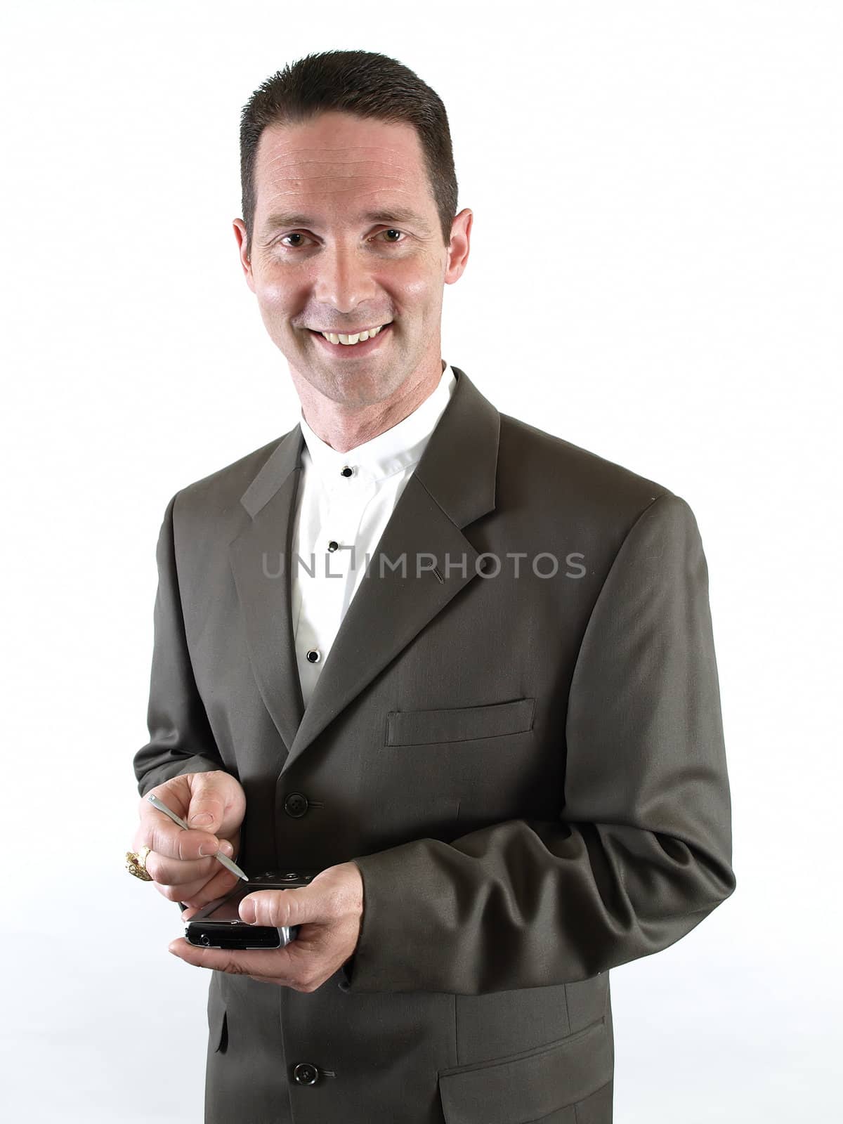 A smiling businessman in a suit holds a pda in his hand, ready to make a note.