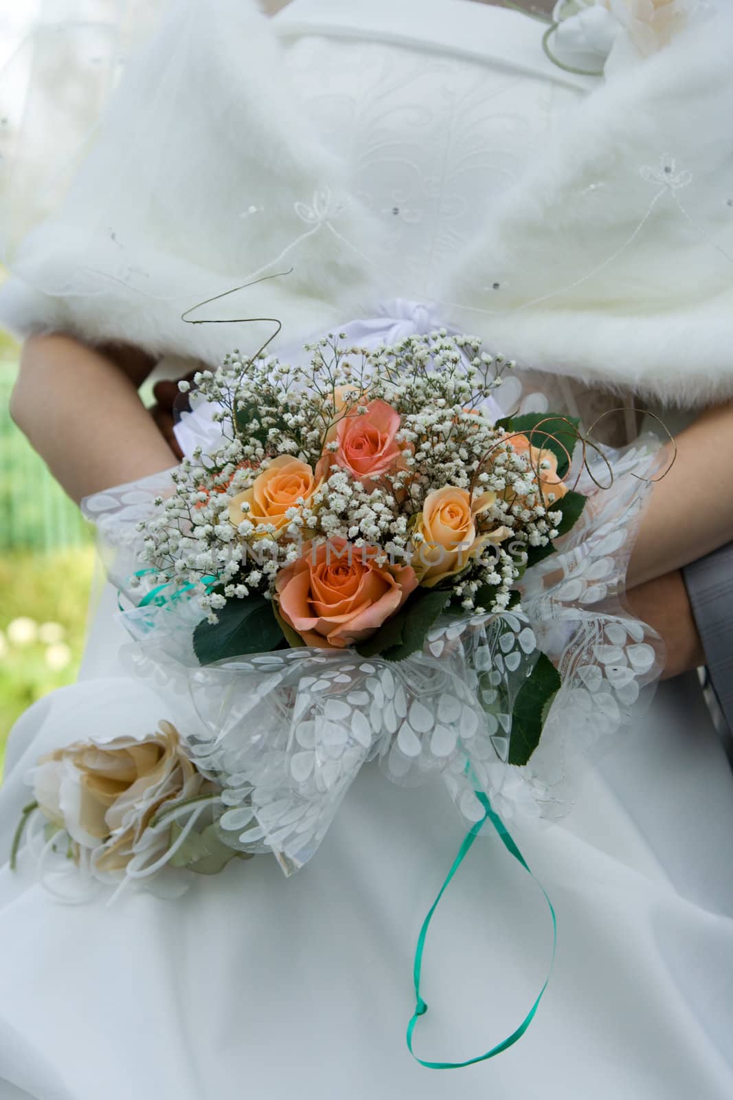 Wedding bouquet in hands of the groom and the bride