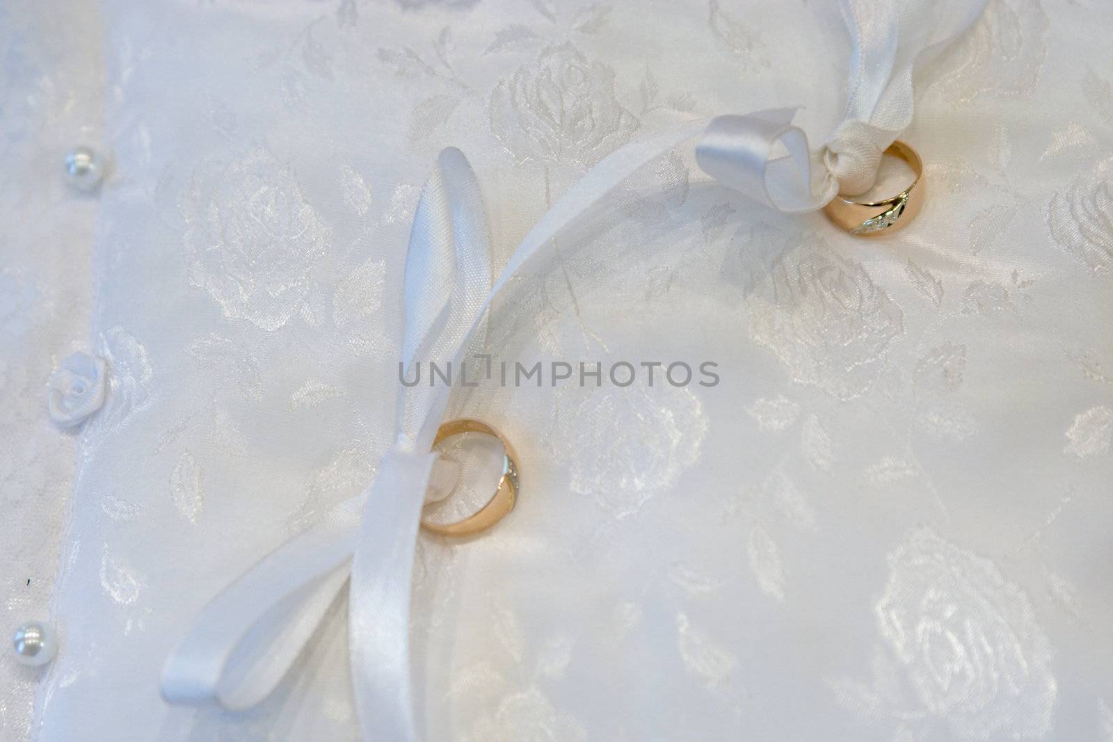 Gold wedding rings on a pillow