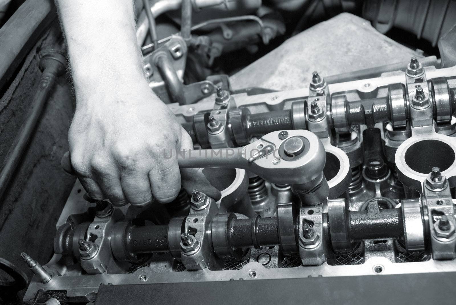 Repair of the engine. A hand with the tool. Automobile service.monochrome