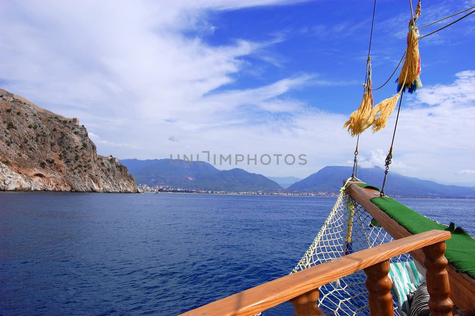part of boat, ropes and rocky land