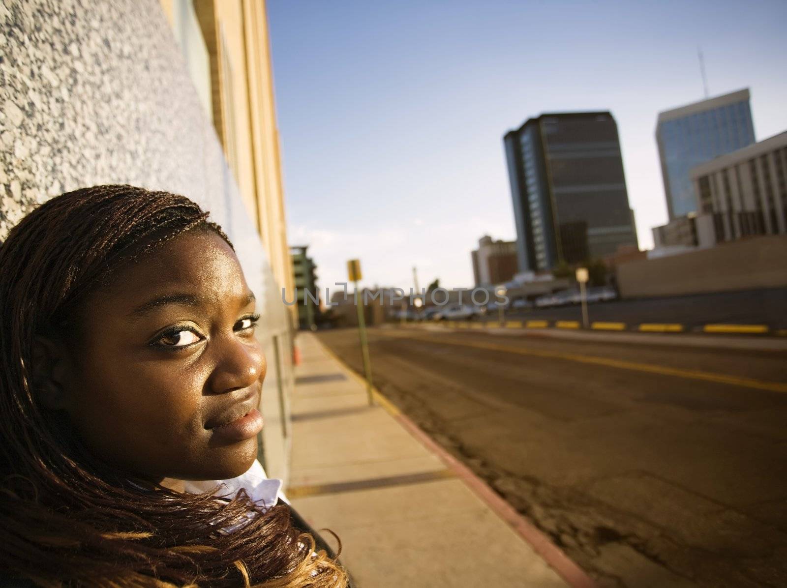 Closeup of a pretty African American woman leaning on a building