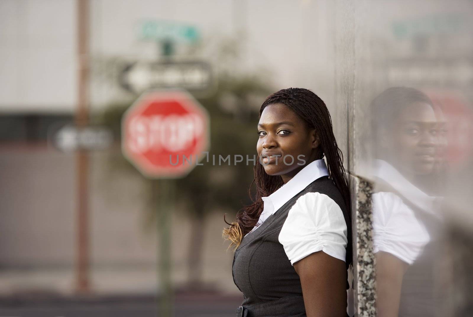 Closeup of a pretty African American woman leaning on a building