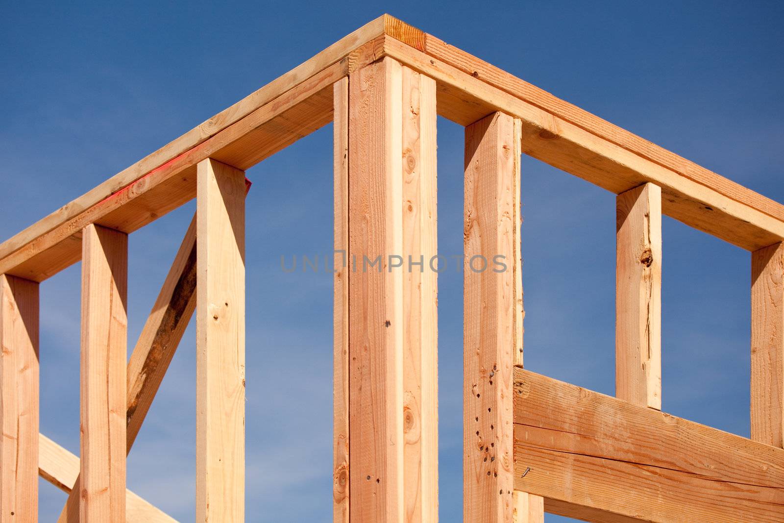 New Residential Home Construction Framing Site Against Blue Sky.