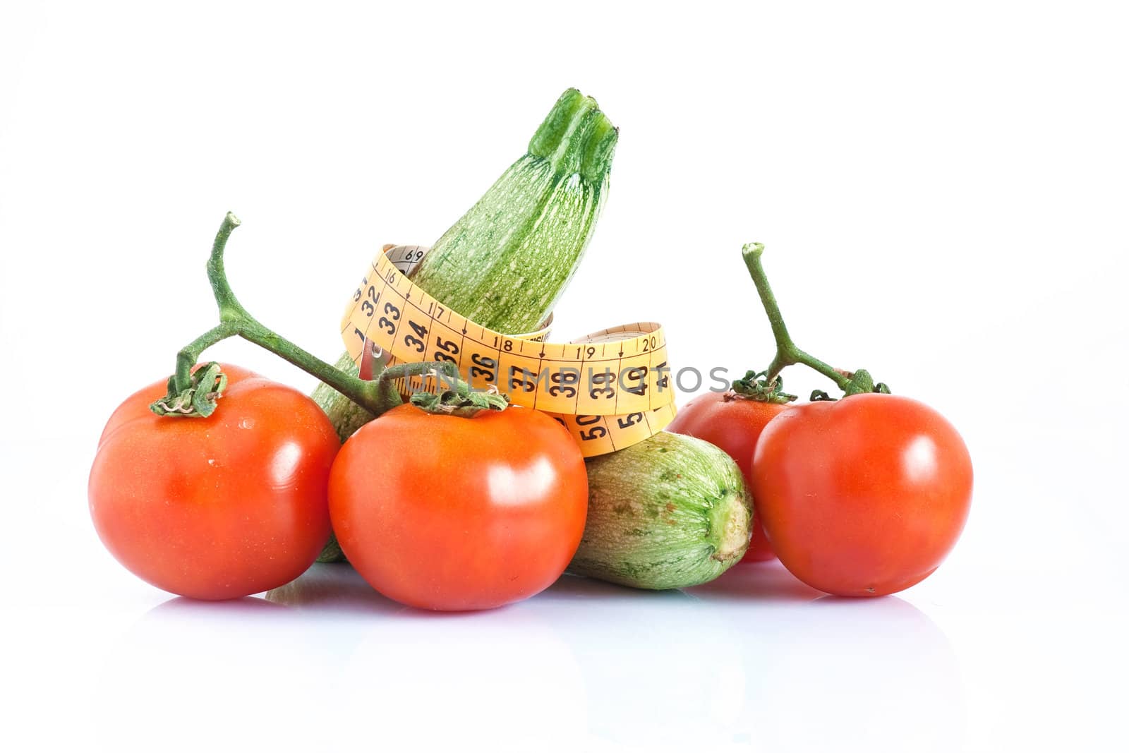 two courgettes and tomatoes with meter isolated on white background