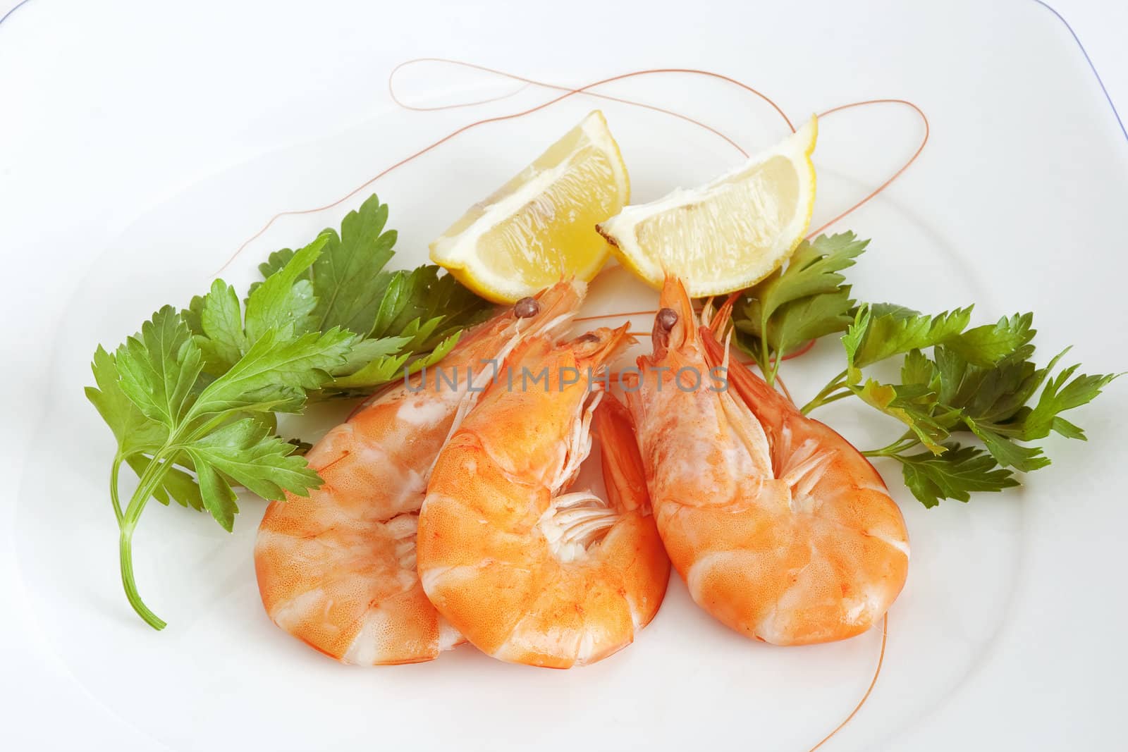 three raw prawns with lemon and parsley on a white plate