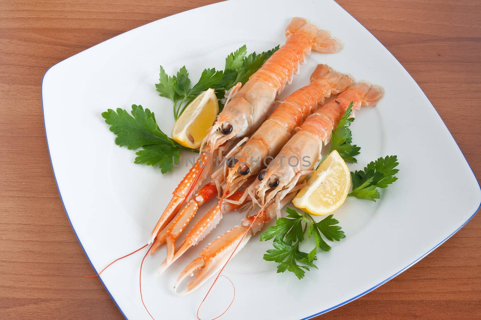 prawns with lemon and parsley on a white plate