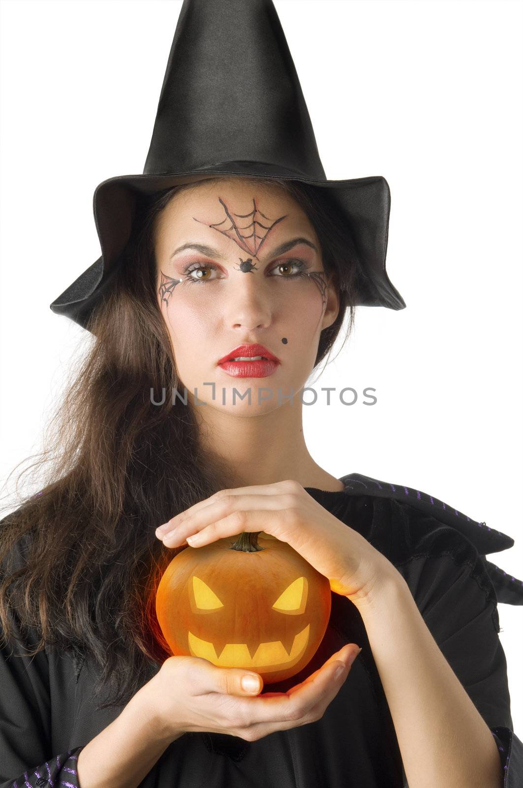 cute girl with witch hat and a little pumpkin betweeen hands