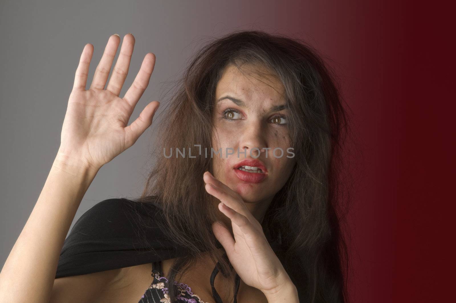 young woman in fear and keeping up hands as to defend from hit