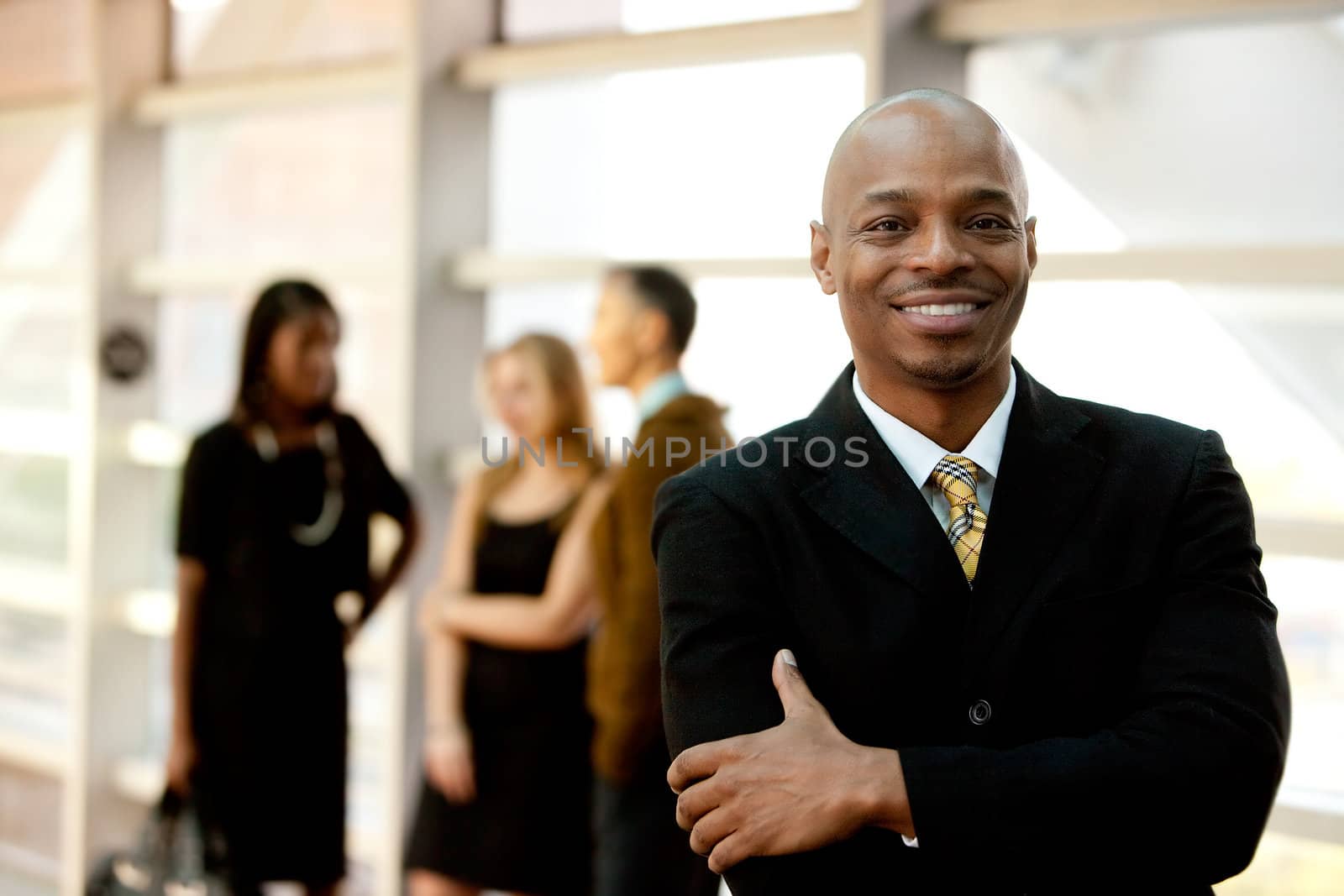 A happy black business man with people in the background