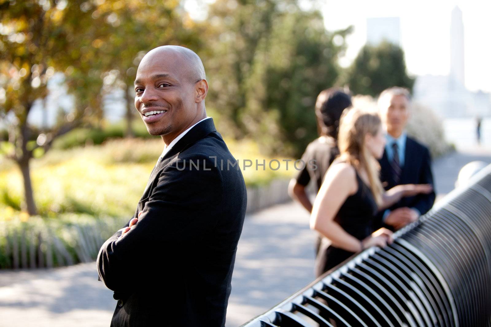 A group of business colleagues in the park - focus on front man